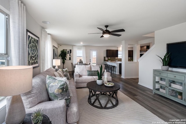 living room with dark wood-type flooring and ceiling fan