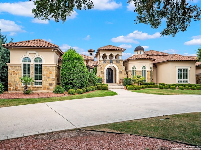 mediterranean / spanish-style home featuring a front yard