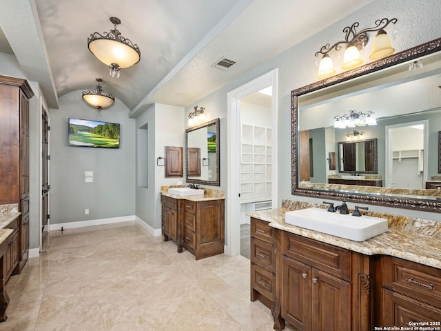 bathroom with lofted ceiling and vanity