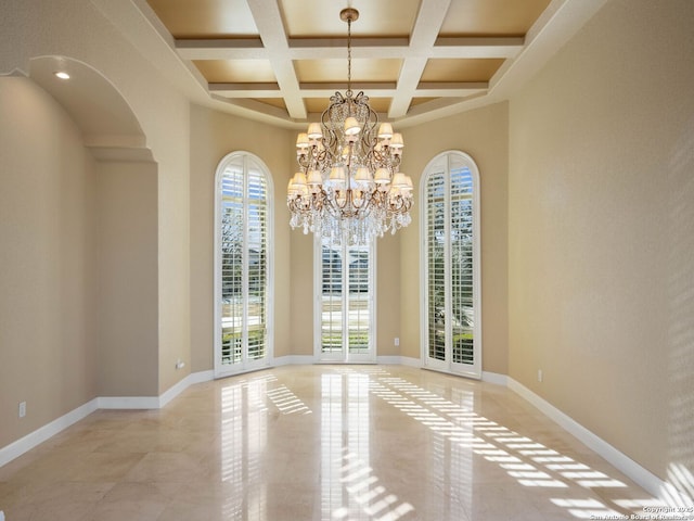 unfurnished dining area featuring beamed ceiling, a healthy amount of sunlight, coffered ceiling, and a notable chandelier