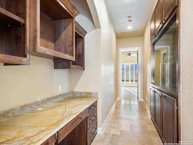 kitchen featuring light stone counters and a textured ceiling