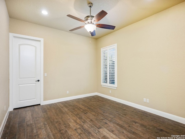 spare room with dark wood-type flooring and ceiling fan