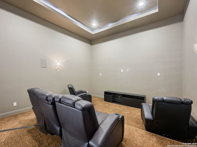 cinema room featuring carpet floors and a raised ceiling