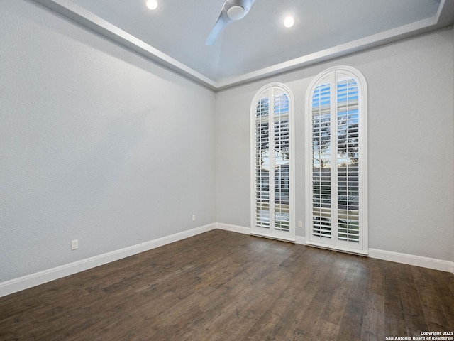 spare room featuring dark wood-type flooring and ceiling fan