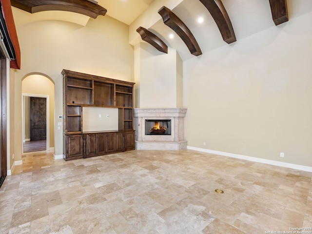 unfurnished living room featuring a high ceiling and a fireplace