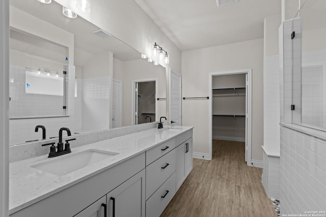 bathroom with vanity, hardwood / wood-style floors, and a tile shower