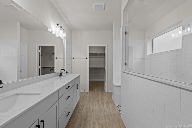 bathroom featuring vanity, hardwood / wood-style flooring, and tiled shower