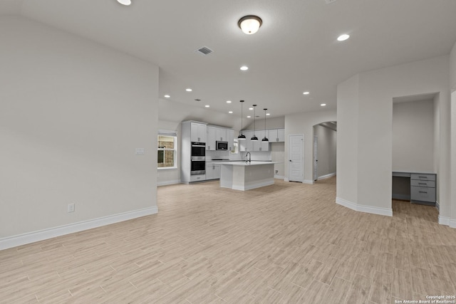 unfurnished living room featuring sink