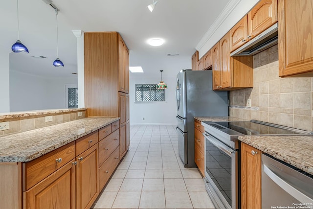 kitchen with light tile patterned flooring, appliances with stainless steel finishes, light stone counters, and decorative light fixtures