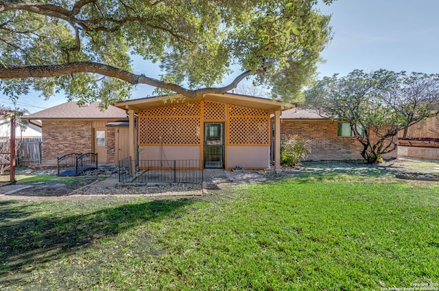 rear view of property with a yard