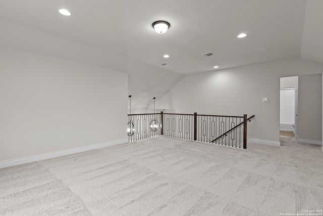 empty room with vaulted ceiling and light carpet