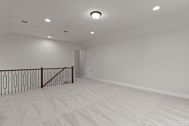 unfurnished room featuring vaulted ceiling and light carpet