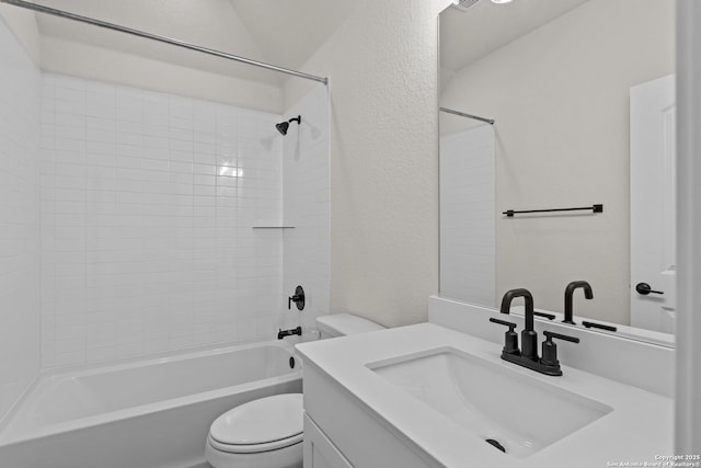 full bathroom with tiled shower / bath, vanity, and toilet