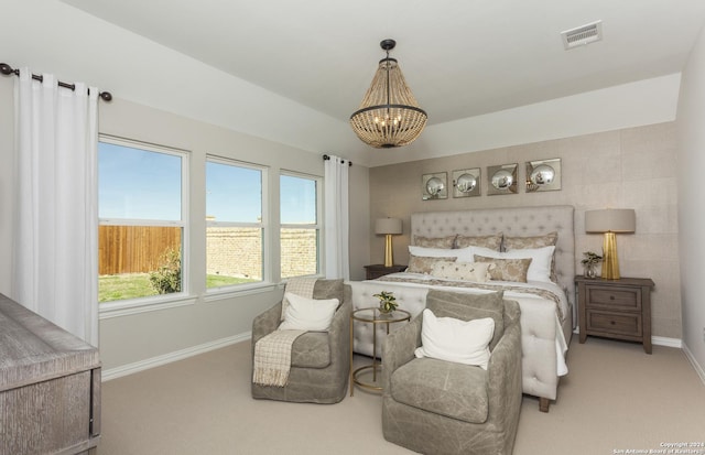 carpeted bedroom featuring multiple windows and a notable chandelier