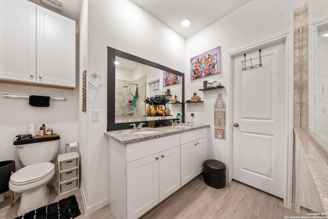 bathroom with walk in shower, wood-type flooring, toilet, and vanity