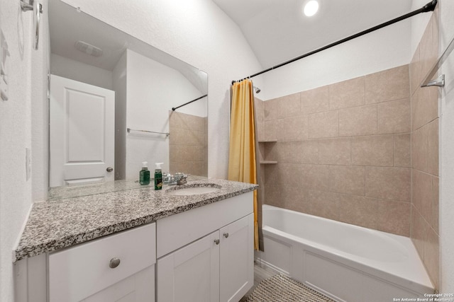 bathroom with vanity, vaulted ceiling, and shower / bath combo with shower curtain