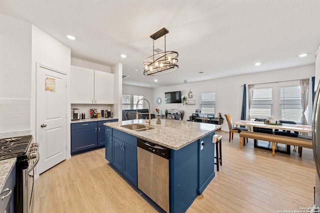 kitchen featuring sink, white cabinetry, hanging light fixtures, stainless steel appliances, and decorative backsplash