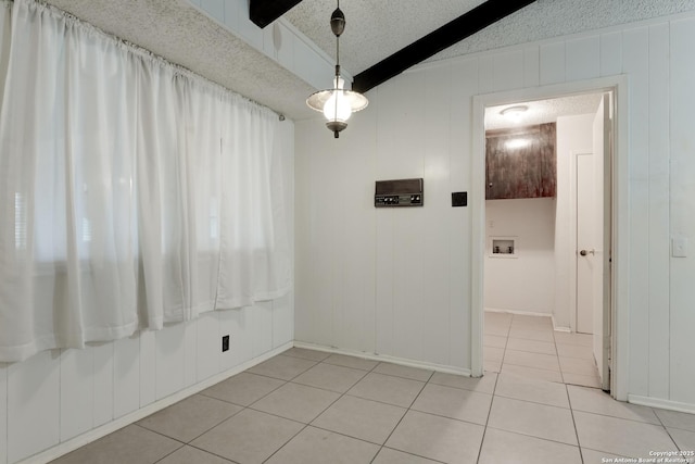 tiled spare room featuring wooden walls