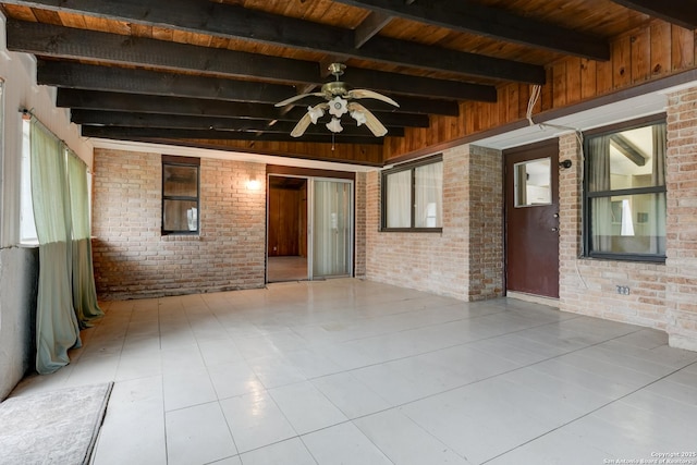 spare room featuring light tile patterned floors, wooden ceiling, beamed ceiling, and brick wall