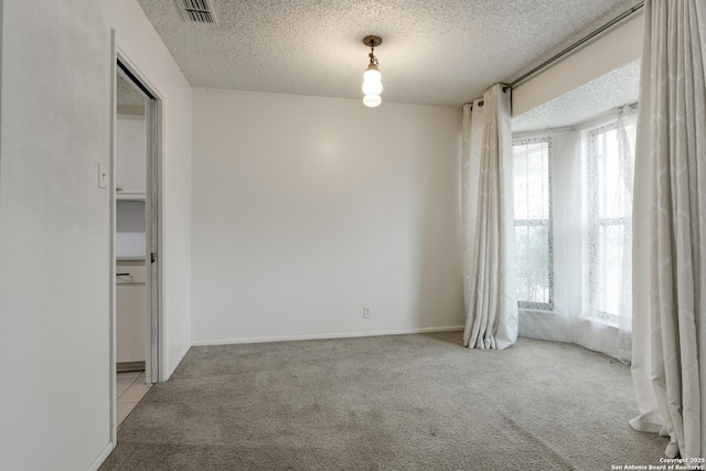 carpeted empty room with a textured ceiling