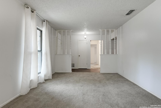 spare room with a textured ceiling and carpet flooring