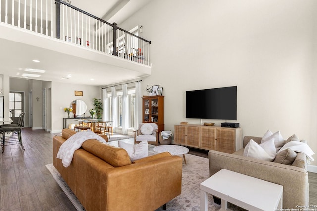 living room with a towering ceiling and hardwood / wood-style floors