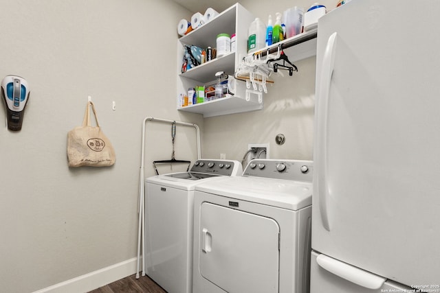 clothes washing area with independent washer and dryer and dark hardwood / wood-style flooring