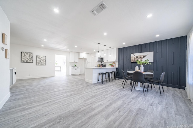 dining space with light hardwood / wood-style floors