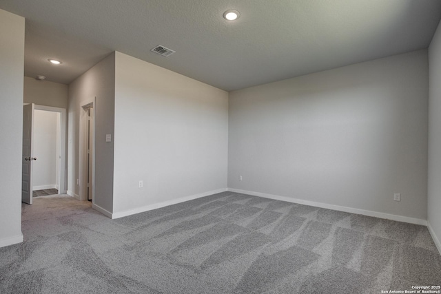 spare room featuring recessed lighting, visible vents, carpet flooring, a textured ceiling, and baseboards