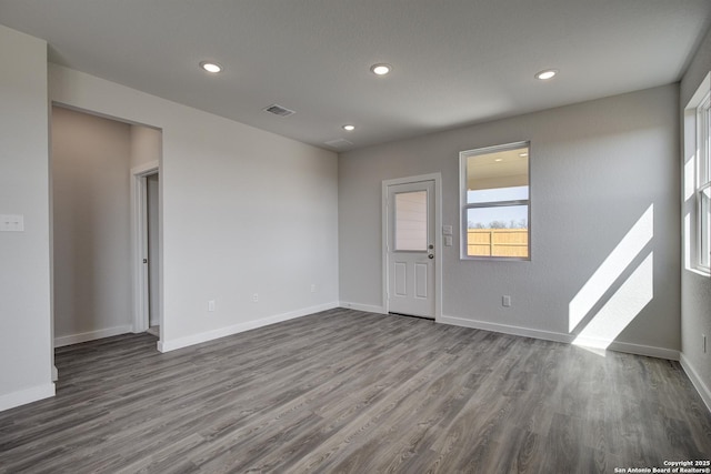 unfurnished room with dark wood-type flooring, recessed lighting, visible vents, and baseboards
