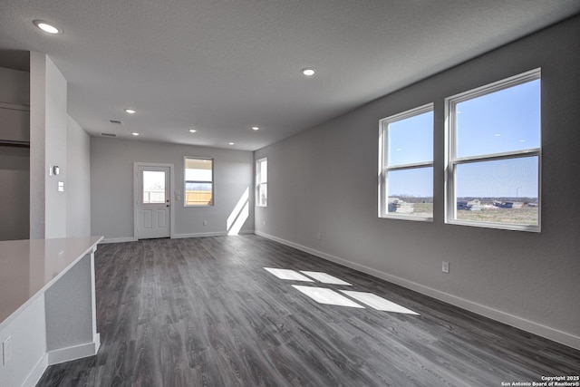 unfurnished room featuring dark wood-style floors, recessed lighting, a textured ceiling, and baseboards