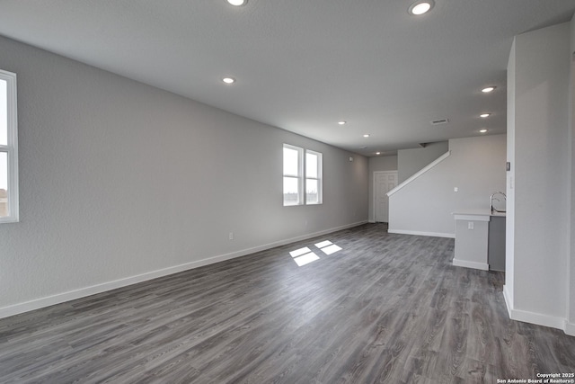 empty room featuring stairway, recessed lighting, dark wood finished floors, and baseboards