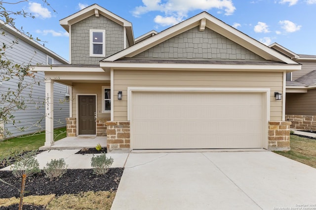 craftsman-style house with an attached garage, stone siding, and driveway