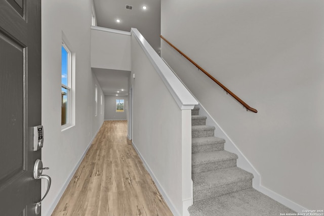 foyer featuring recessed lighting, a high ceiling, visible vents, baseboards, and light wood-type flooring