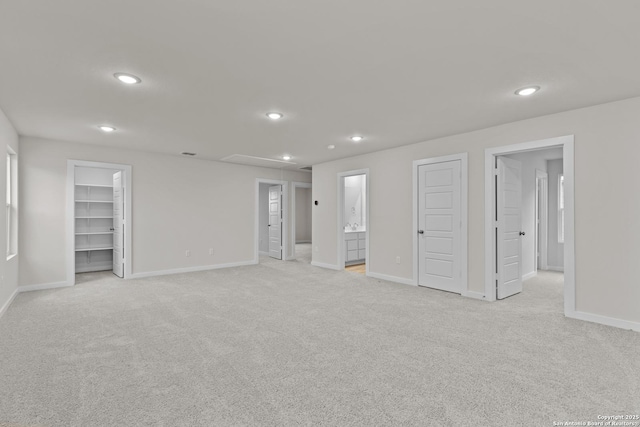 unfurnished bedroom featuring attic access, recessed lighting, light colored carpet, and a spacious closet