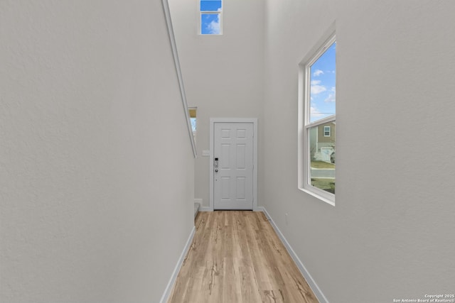 hall featuring light wood finished floors and baseboards