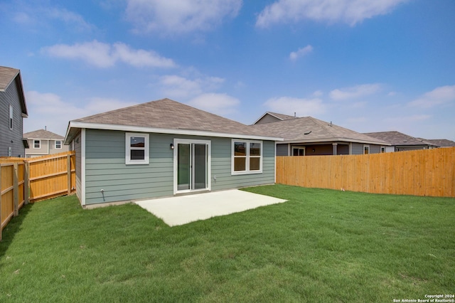 back of property with a patio area and a lawn