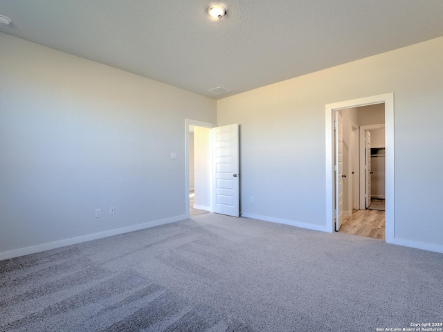 unfurnished bedroom with light carpet and a textured ceiling