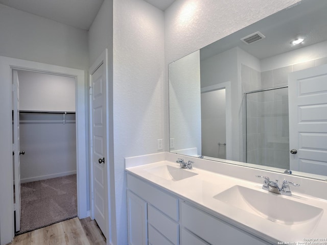 bathroom featuring vanity, wood-type flooring, and walk in shower