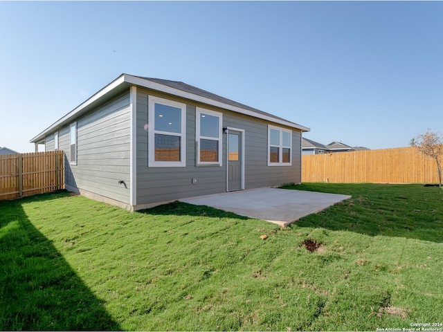 back of house with a lawn and a patio area