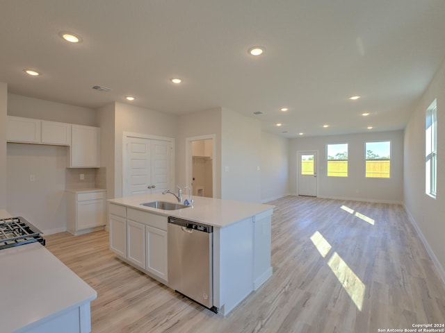 kitchen featuring dishwasher, an island with sink, sink, white cabinets, and light hardwood / wood-style floors