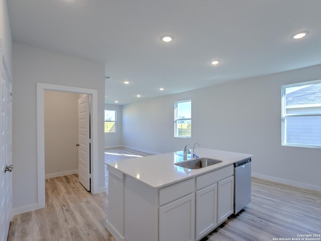 kitchen with sink, light hardwood / wood-style flooring, dishwasher, a kitchen island with sink, and white cabinets