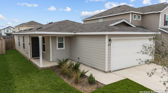 rear view of house featuring a garage and a lawn