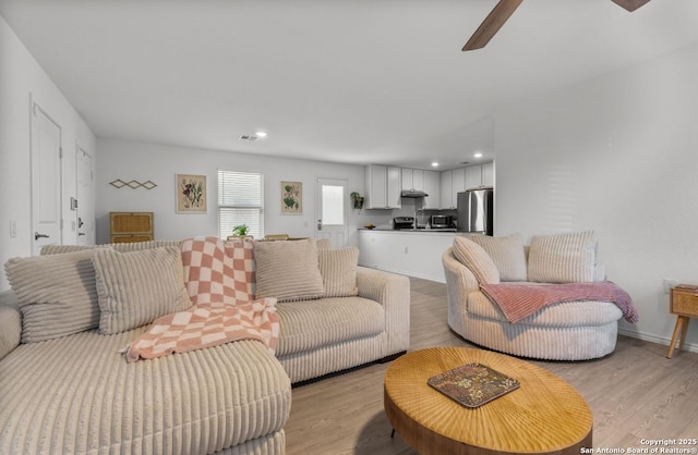 living room featuring ceiling fan and light wood-type flooring