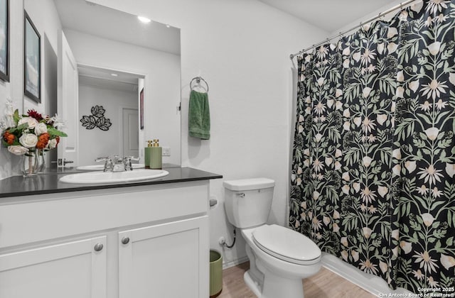 bathroom featuring hardwood / wood-style flooring, vanity, a shower with shower curtain, and toilet