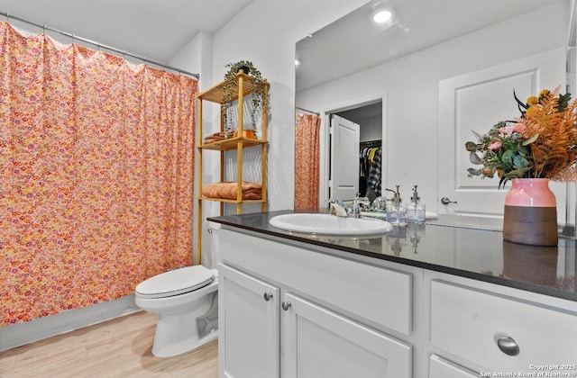 bathroom featuring wood-type flooring, vanity, and toilet