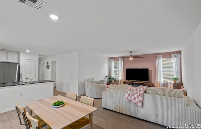 dining room with ceiling fan, a healthy amount of sunlight, and light wood-type flooring