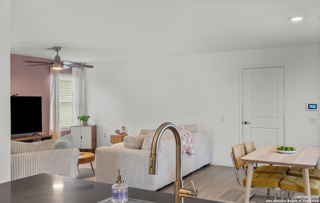 living room featuring ceiling fan and light hardwood / wood-style floors