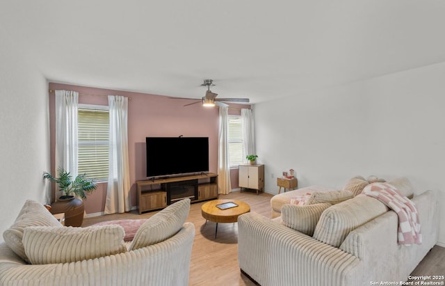 living room with ceiling fan and light hardwood / wood-style flooring