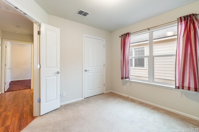 unfurnished bedroom featuring light colored carpet